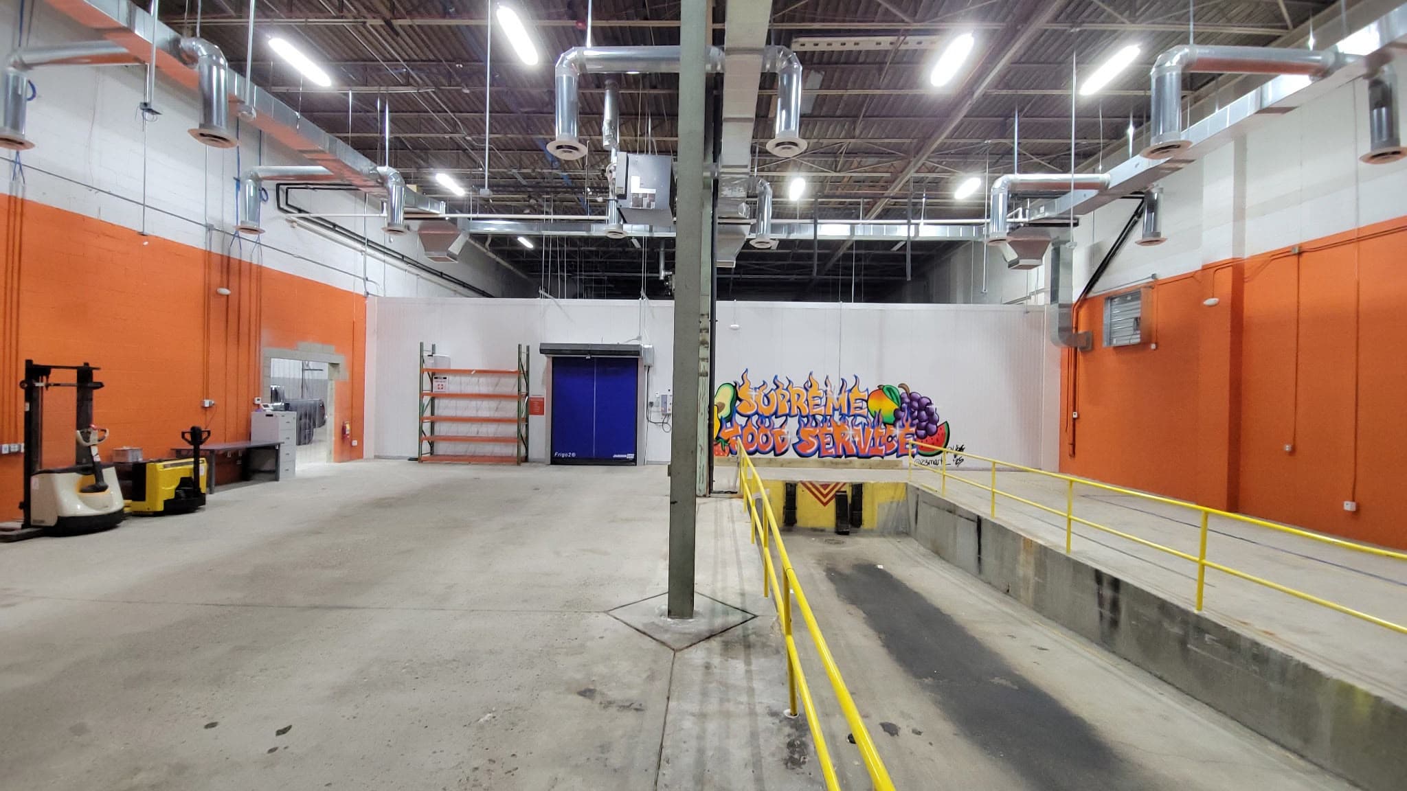 Inside the new facility, with the Supreme Food Service mural